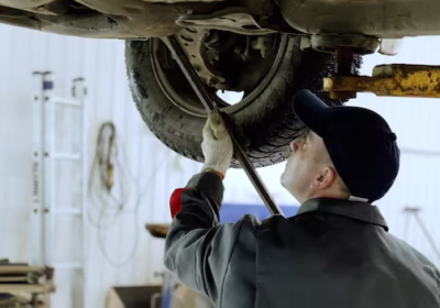 skilled-automotive-technician-checking-vehicle-undercarriage-with-pry-bar